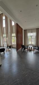 a room with benches and tables in a room with windows at The white house in Douala
