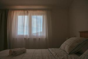 a bedroom with a bed and a window at Sevid Seaview Apartments in Sevid