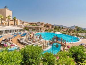 a large swimming pool with chaise lounges and chairs at Magnifique vue mer - 2 pièces climatisé avec terrasse à Cap Estérel in Saint-Raphaël