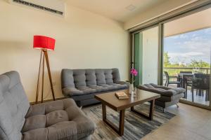 a living room with two couches and a table at La Poza Suites in Isla Mujeres