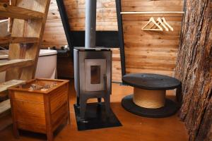 a wood stove in a room with a table at Chalé Encanto Do Lago in Urubici +66 photos