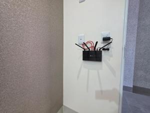 a white wall with a black holder with red wires at Apartamento Aconchegante 103 Palmeiras de Goiás in Palmeiras de Goiás +24 photos
