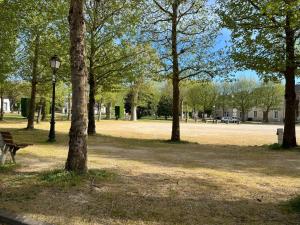 a park with a bench and trees and a street light at Le refuge des Ormes in Les Ormes