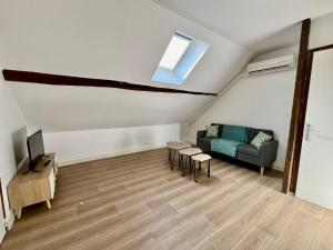 a living room with a couch and a television at Le refuge des Ormes in Les Ormes