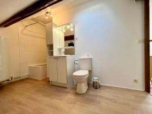 a white bathroom with a toilet and a sink at Le refuge des Ormes in Les Ormes
