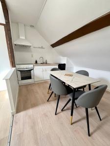 a kitchen and dining room with a table and chairs at Le refuge des Ormes in Les Ormes +2 photos