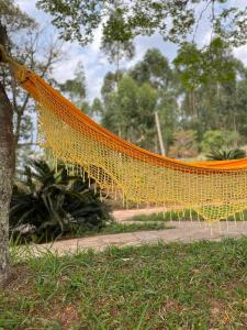 an orange net hanging from a tree in a park at Loft no Sul de Minas in Baependi