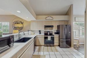 a large kitchen with a sink and a refrigerator at On the Green in Branson