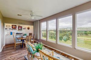 a living room with a table and chairs and windows at On the Green in Branson