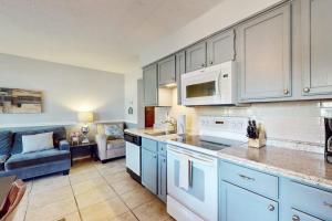 a kitchen with white appliances and a living room at Fall Creek Resort Pond View Escape in Branson