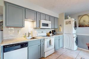 a kitchen with white appliances and blue cabinets at Fall Creek Resort Pond View Escape in Branson