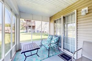 a porch with a chair and a table and windows at Fall Creek Resort Pond View Escape in Branson