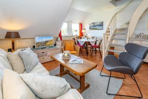a living room with a couch and a table at Wattblick in Braderup