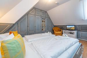 a bedroom with two beds and a flat screen tv at Wattblick in Braderup