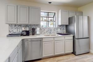 a kitchen with white cabinets and a stainless steel refrigerator at Waterview Oasis in Branson +15 photos