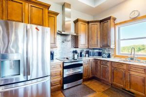 a kitchen with wooden cabinets and a stainless steel refrigerator at Treetop View Sanctuary in Branson
