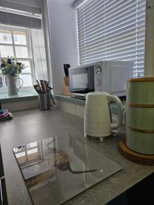 a kitchen counter with a coffee maker and a microwave at Kirkwall Flat 1 in Orkney