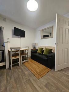 a living room with a black couch and a table at Kirkwall Flat 1 in Orkney