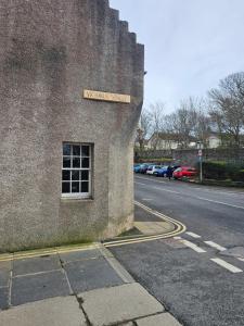 a building with a sign on the side of a street at Kirkwall Flat 1 in Orkney +3 photos