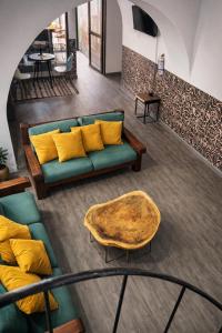 a living room with a green couch and yellow pillows at Seven Nights Hostel Cartagena in Cartagena de Indias