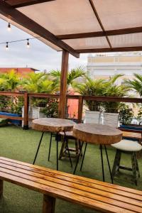 two picnic tables and chairs on a patio with palm trees at Seven Nights Hostel Cartagena in Cartagena de Indias