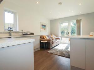 a kitchen and living room with a couch at Little Pippin in Carlyon Bay