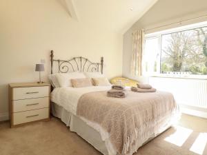 a bedroom with a bed with towels on it at Little Pippin in Carlyon Bay