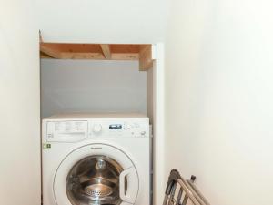a laundry room with a washer and dryer at Little Pippin in Carlyon Bay