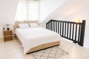 a bedroom with a bed with a black crib at Duplex cosy au cœur de Sinnamary, fleuve à pied- Samélé House in Sinnamary