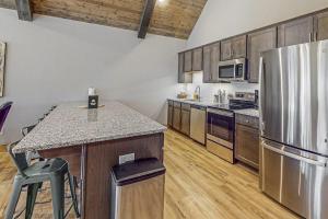 a kitchen with a stainless steel refrigerator and wooden cabinets at Cozy Cove Lodge in Branson +23 photos