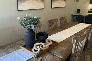 a wooden table with a blue vase of flowers on it at Cozy Cove Lodge in Branson