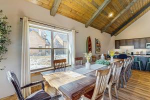 a dining room with a wooden table and a large window at Cozy Cove Lodge in Branson