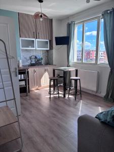 eine Küche und ein Wohnzimmer mit Tisch und Stühlen in der Unterkunft Studio Aloe in Dunkerque