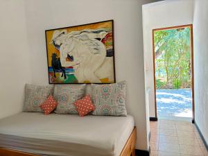a room with a couch with a painting on the wall at Casita Gitza in Montezuma