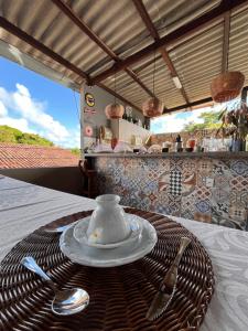 a tea set on a table with a plate and spoon at Flor do Mar - Hospedaria in Santa Cruz