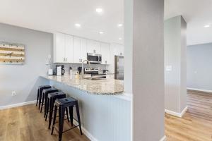a kitchen with white cabinets and a bar with stools at Hole in One in Branson