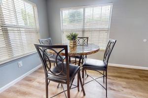 a dining room with a table and chairs and windows at Hole in One in Branson