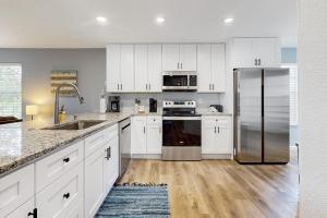 a kitchen with white cabinets and a stainless steel refrigerator at Hole in One in Branson