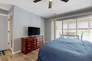 a bedroom with a bed and a flat screen tv at Hole in One in Branson +16 photos