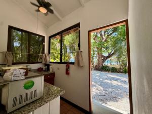 a kitchen with a door to a yard with a tree at Casita Gitza in Montezuma
