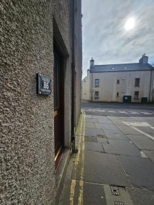 a sign on the side of a building next to a street at Kirkwall Flat 1 in Orkney