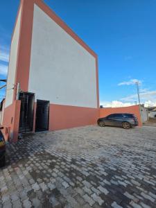a car parked in front of a building with a large screen at Apartamento Aconchegante 103 Palmeiras de Goiás in Palmeiras de Goiás