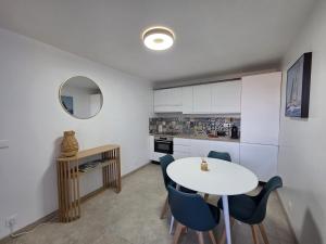 a kitchen with a table and blue chairs in a room at A Casa di Minana in Piana