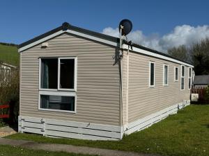 a small white building with a window at Bag End, Near Porth Beach, Garden & Stream in Newquay Bay Resort
