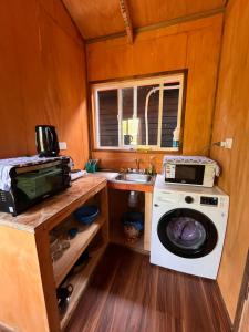 a kitchen with a washing machine and a sink at Cabañas Villegas C2 in Hornopiren