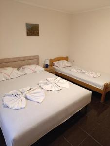 two beds in a hotel room with bows on them at Apartments Nenadić in Utjeha