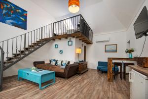 a living room with a couch and a staircase at Red Stone in Kővágóörs