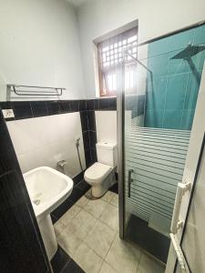 a bathroom with a sink and a toilet and a shower at Tea Estate Villa in Ratnapura