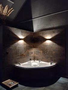 a bathroom with a bath tub with lights on the wall at Red Stone in Kővágóörs +50 photos