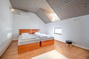 two beds in a room with a vaulted ceiling at Red Stone in Kővágóörs